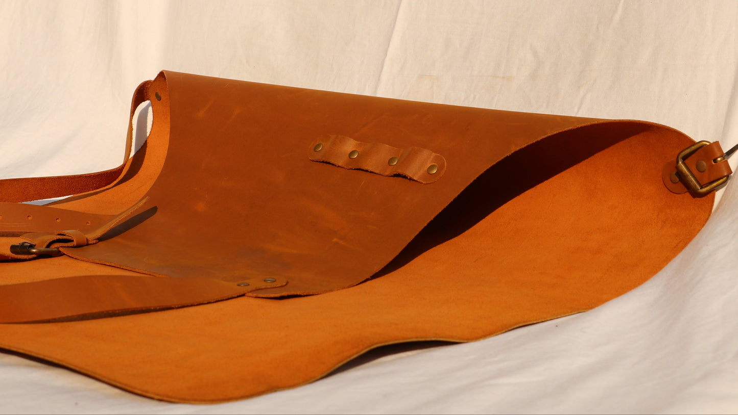 Brown leather apron folded on a white fabric background